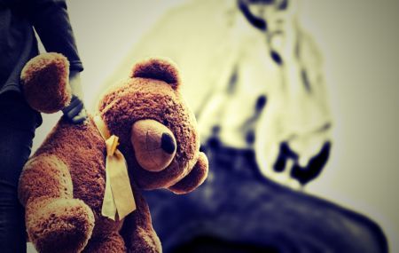 child holding stuffed bear