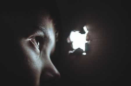 Person staring out a hole